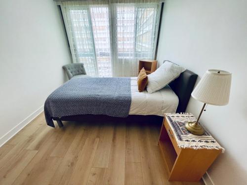 une chambre avec un lit et une table avec une lampe dans l'établissement 3 Pieces Convention Avec Piscine, à Paris