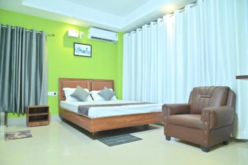 a bedroom with a bed and a chair at Hotel Air Inn in Guwahati