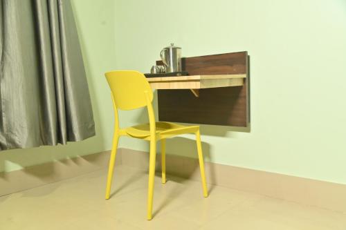 a yellow chair sitting in front of a desk at Hotel Air Inn in Guwahati