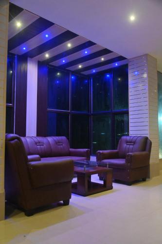a living room with couches and a table and blue lights at Hotel Air Inn in Guwahati