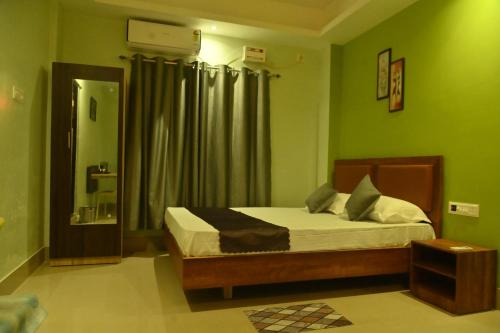 a bedroom with a bed with green walls at Hotel Air Inn in Guwahati