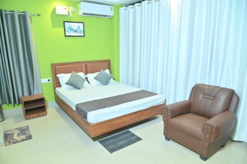a bedroom with a bed and a chair at Hotel Air Inn in Guwahati