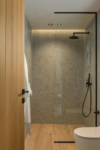 a bathroom with a shower and a toilet and a sink at Monalia suites in Parga