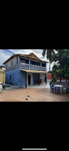 a blue building with a balcony and a table at Casa em Porto do Sauipe in Entre Rios