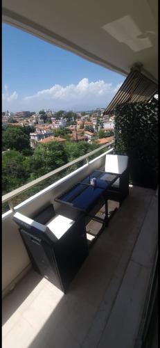 un balcon avec une table et une vue sur une ville dans l'établissement Antibes beau studio lumineux, à Antibes