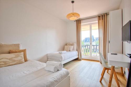 Cette chambre blanche dispose d'un bureau et d'un lit. dans l'établissement La Villa Normande - La Suite - Deauville, à Deauville
