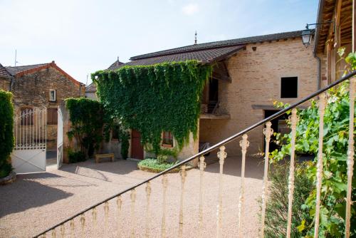 an ivy covered fence in front of a building at Le Logis D'Azé in Azé