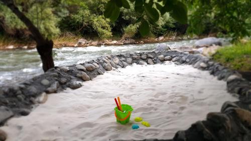 a drink cup in the water next to a river at Areni Lodge in Areni