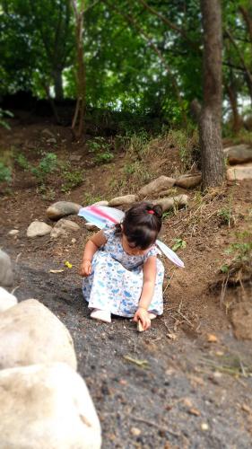a little girl sitting on a road with an umbrella at Areni Lodge in Areni