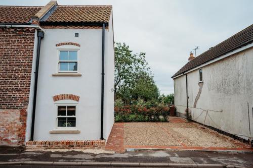 Una casa blanca con una ventana en el costado. en ThePiggery No 14, en Haxey