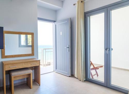 a room with a mirror and a desk and sliding doors at Blue Sea Paros in Drios