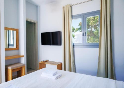 a bedroom with a white bed and a window at Blue Sea Paros in Drios