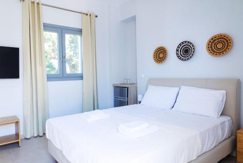 a bedroom with a white bed and a window at Blue Sea Paros in Drios