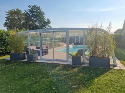 - un kiosque avec piscine dans la cour dans l'établissement chambre d hote piscine proximite etretat piscine ouverte du 15 avril au 30 septembre, à Mirville