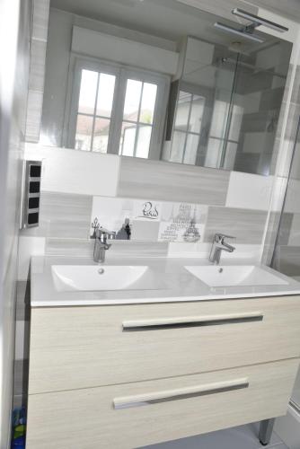 アニエール・シュル・セーヌにあるLe Clos Ménilの洗面台が2つと鏡があるバスルーム