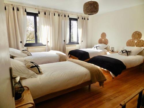 a bedroom with three beds in a room at Gîte La Part des Anges in Saint-Angel