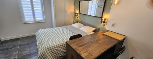 a small bedroom with a bed and a wooden table at "Le duo" studio cosy au cœur d'Epernay in Épernay