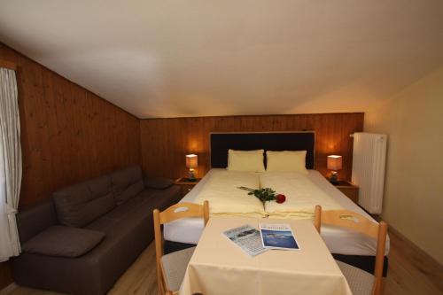 a bedroom with a large bed and a couch at Gästehaus -Pension Edelweiss in Vent