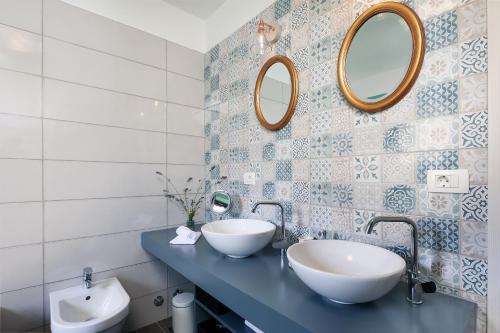 a bathroom with two sinks and two mirrors at Apartman Kalinda in Rijeka