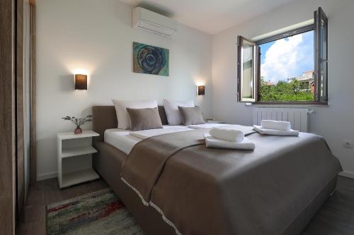 a bedroom with two beds and a window at Apartman Kalinda in Rijeka