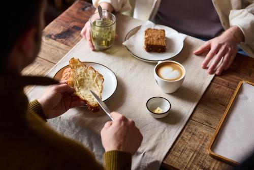 a person eating a slice of cake at a table at The Usual Rotterdam in Rotterdam