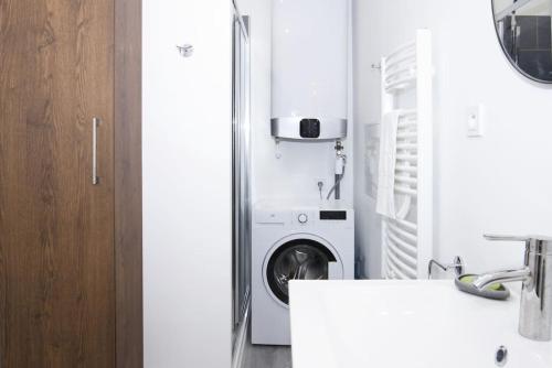 une cuisine avec une laveuse et une sécheuse à côté d'un réfrigérateur dans l'établissement Cahino, déco contemporaine, clim, parking, à La Ciotat