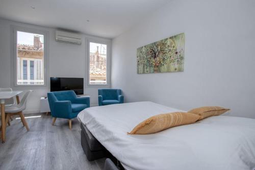 une chambre avec un lit, une table et des chaises dans l'établissement Cahino, déco contemporaine, clim, parking, à La Ciotat