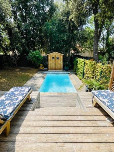 une petite piscine avec deux bancs et une maison dans l'établissement Villa 3 chambres Piscine Jardin à 15m d'Aix-en-Provence, à Venelles