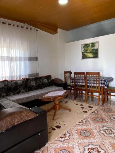 a living room with a couch and a table and chairs at Noemi House in Krujë