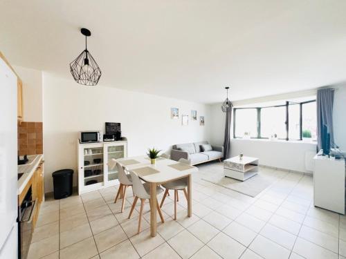 une cuisine et un salon avec une table et des chaises dans l'établissement Appartement Coquelicot 25km Paris et Disney, à Pontault-Combault