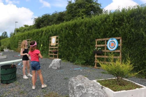 two girls standing next to a garden with a target at La Roulotte d'Ala-Daims in Nollevaux