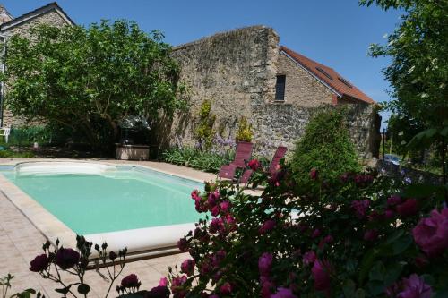 - une piscine en face d'un bâtiment fleuri dans l'établissement Le Nid du Cormier, à Ville-Saint-Jacques
