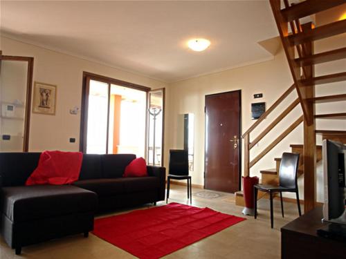 a living room with a black couch and a red rug at Arcobaleno Dante in Arizzano