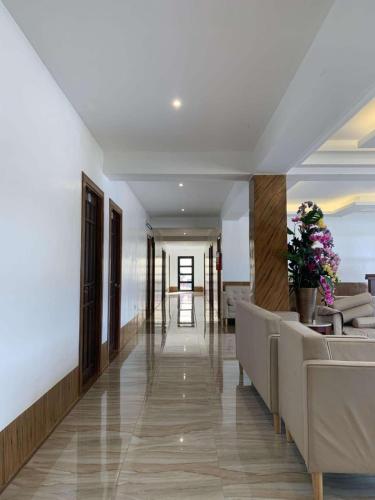 a hallway of a hotel with couches and flowers at DonRio Hotel Siquijor in Siquijor