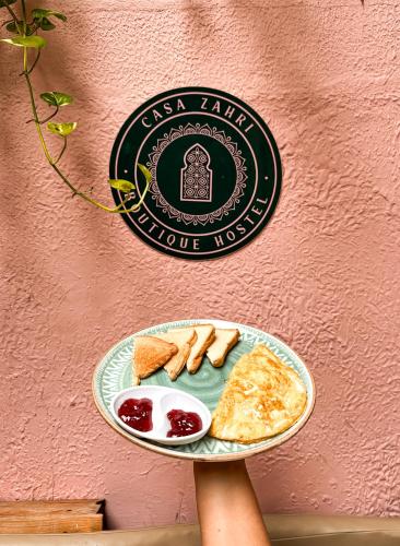 a person holding a plate of food on a wall at Casa Zahri Boutique Hostel in Cartagena de Indias