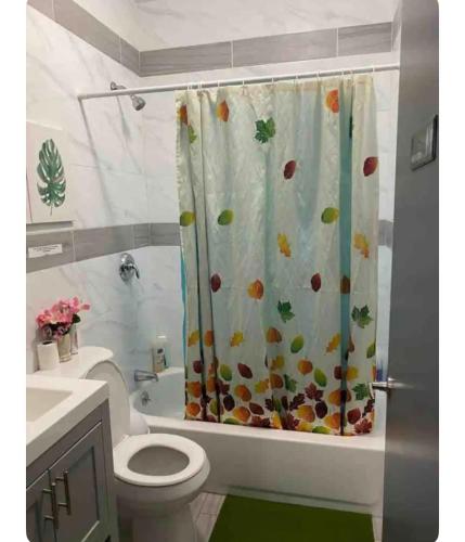 a bathroom with a toilet and a shower curtain at Cozy Room in Newark