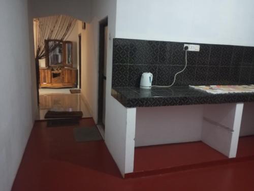 a kitchen counter with a black counter top at Kingjey residence in Kalpitiya