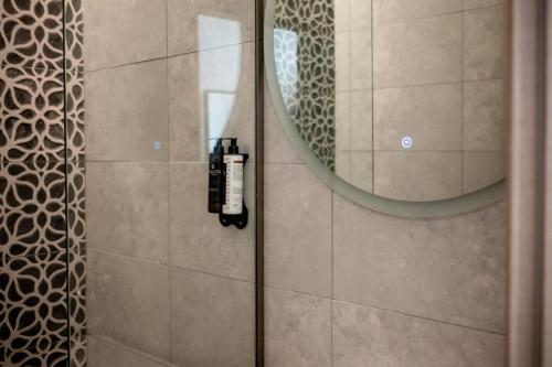 a bathroom with a shower with a mirror at Ocean 11 Hotel in Skiathos Town