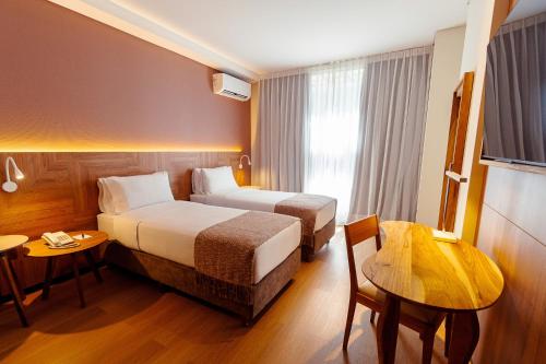 a hotel room with two beds and a table at Brizo Salta in Salta