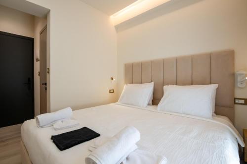 a bedroom with a large white bed with towels on it at Ocean 11 Hotel in Skiathos Town