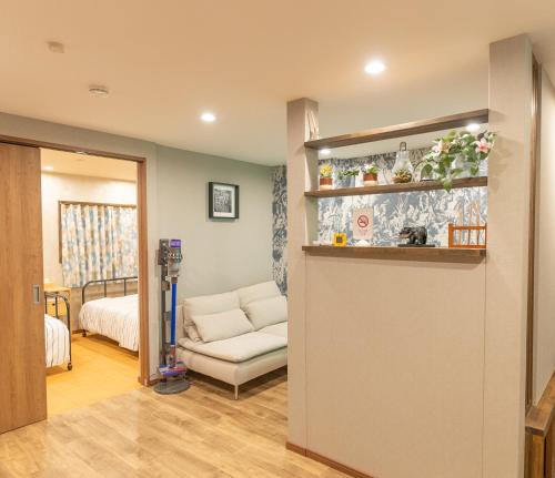 大阪Guest House Kubo Homes Tengachaya 1的客厅配有沙发和1张床