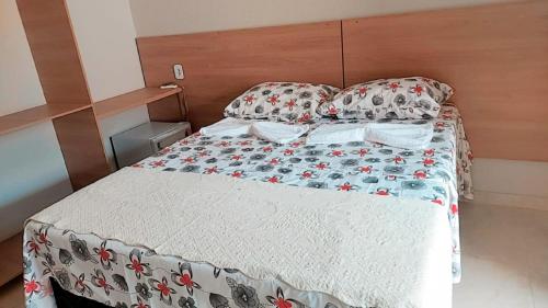 a bedroom with a bed with a white comforter and pillows at Pousada Kactus in Piranhas