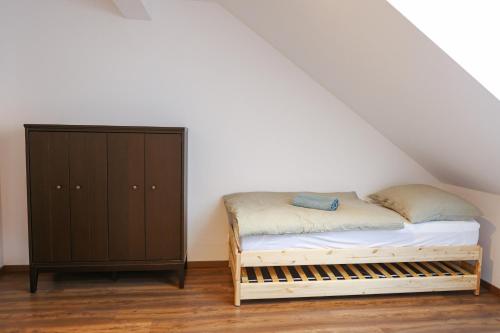 ヤーヒモフにあるApartmán 39 - Baby friendly - Rezidence K Lanovceのベッドと木製のキャビネットのある寝室