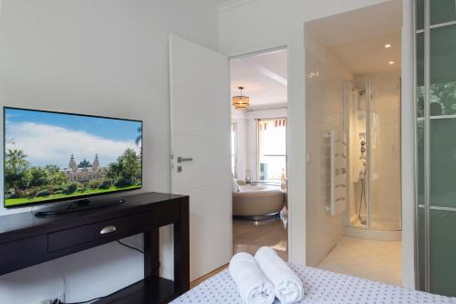 - une chambre avec une télévision et une salle de bains dans l'établissement MONTEVERDI - Appartement 150 m2 - Frontière Monaco - Parking, à Beausoleil
