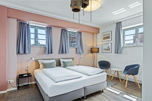 a bedroom with a bed and a table and chairs at Hafenlodge - Urlaub im Denkmal in Wismar