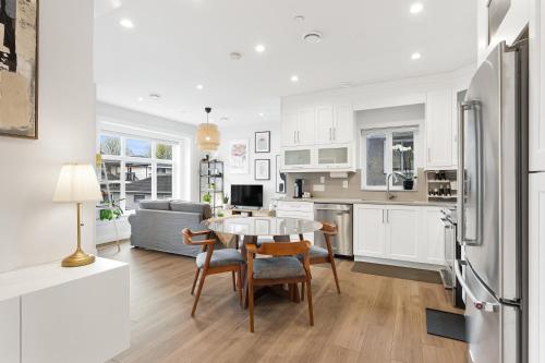 a kitchen and living room with a table and a refrigerator at Charming 3BR Home in a Lovely Vancouver Neighborhood in Vancouver