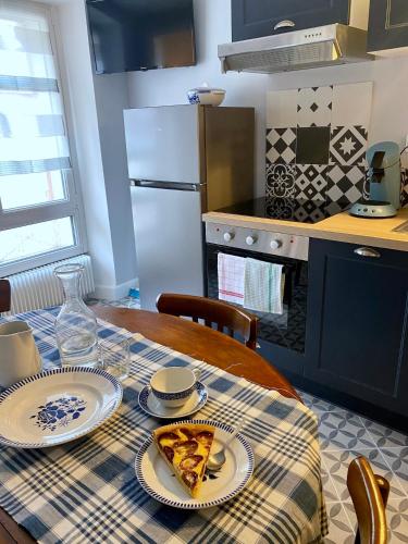 a table with a plate of pizza on it in a kitchen at Hostellerie Alsacienne de Masevaux in Masevaux