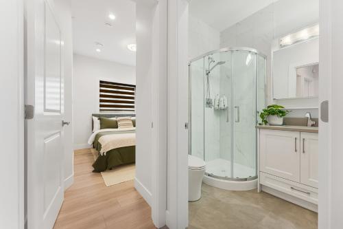 a white bathroom with a shower and a bed at Charming 3BR Home in a Lovely Vancouver Neighborhood in Vancouver