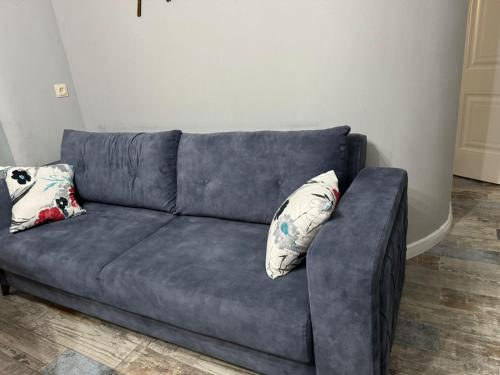 a blue couch in a living room with two pillows at Аппартаменты в гостевом доме in Batumi