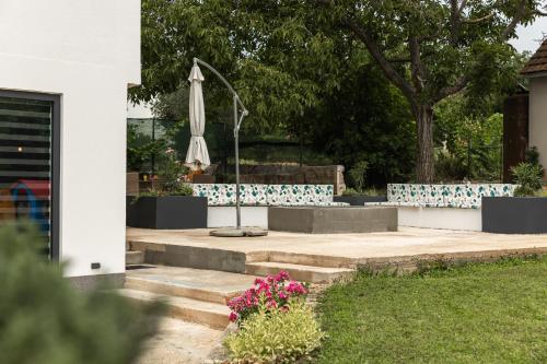 a patio with an umbrella and flowers in a yard at Studio Deluxe RoMa II in Imotski